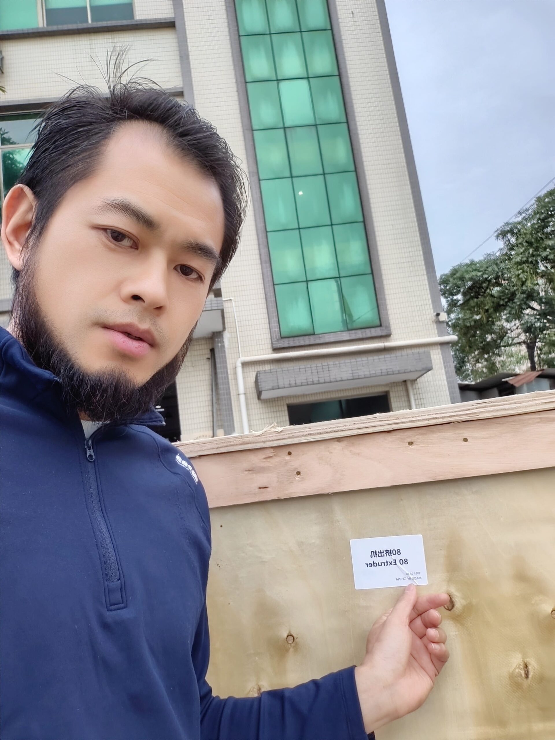 I am standing next to the securely packed plywood shipping crates, ready for export.