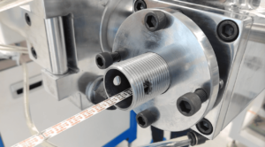 Flexible LED strip PCB being accurately fed into the silicone rubber extrusion crosshead mold.