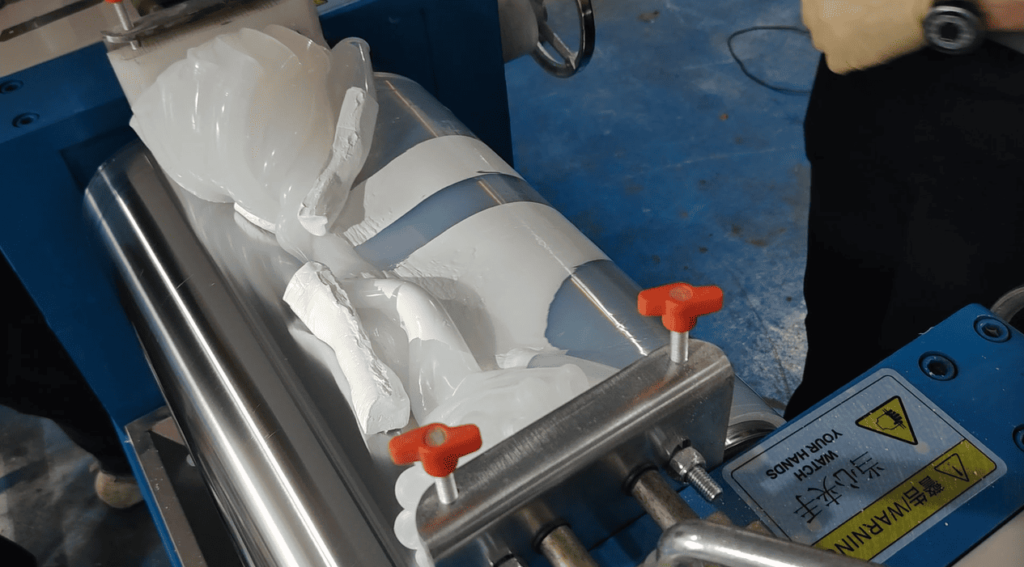 Technician adding opacifying agent (e.g., titanium dioxide) into silicone rubber during the compounding process.