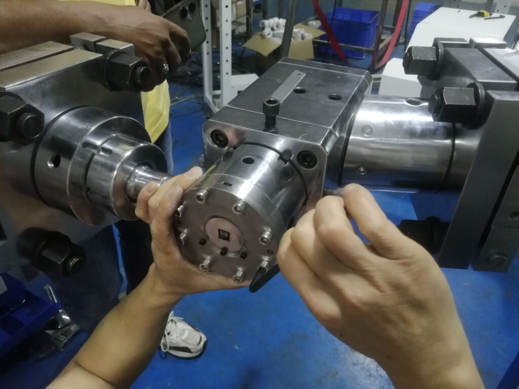 Engineer adjusting the four directional set-screws to fine-tune the mold's concentricity.