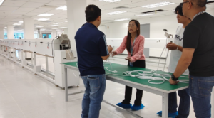 Client's production team discussing quality and specifications of newly extruded silicone LED strip samples at the workshop desk.