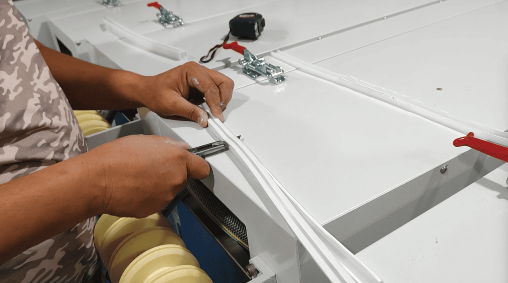 Technician cutting a cured silicone rubber LED strip sample to inspect internal adhesion to the PCB.