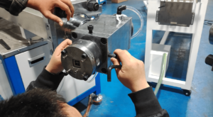 Technician making fine adjustments to the extrusion crosshead mold during machine setup