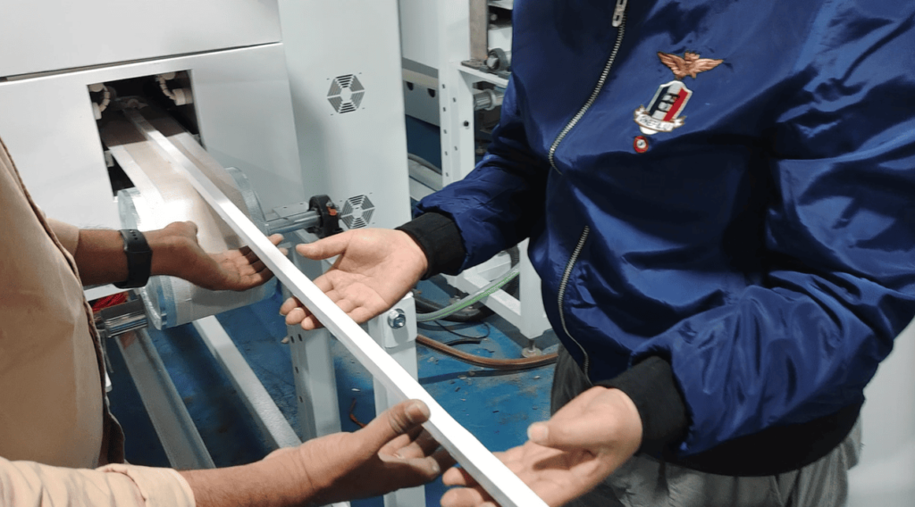 Technician inspecting the soft, uncured silicone rubber strip profile immediately after extrusion