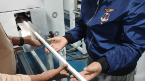 Technician inspecting the soft, uncured silicone rubber strip profile immediately after extrusion