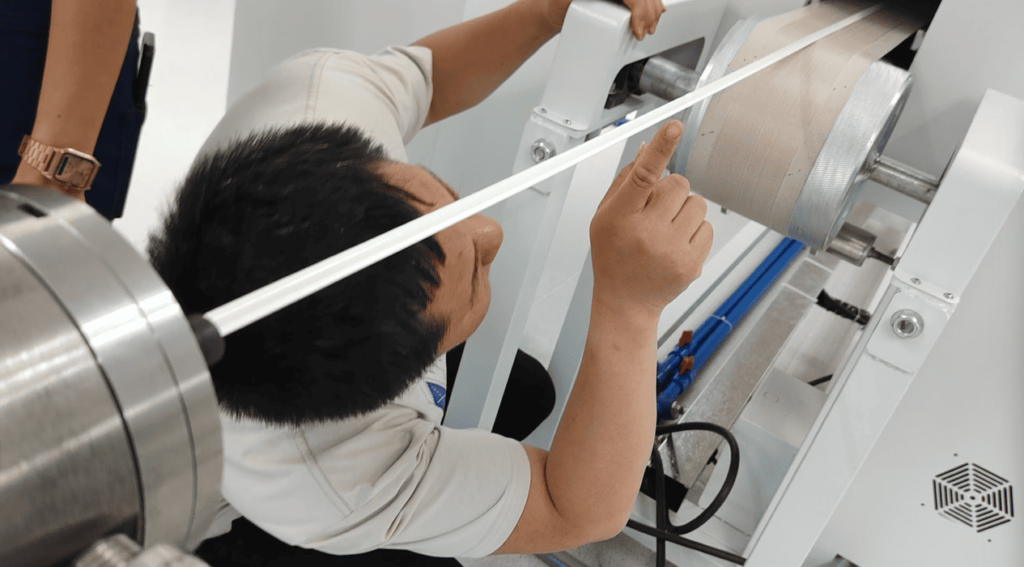 Technician inspecting the bottom surface and adhesive quality of a cured silicone rubber LED strip