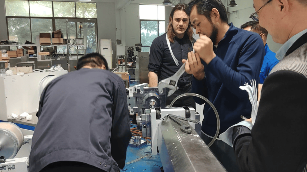 Our engineer disassembling the extrusion mold while guiding the observing customer's maintenance team.