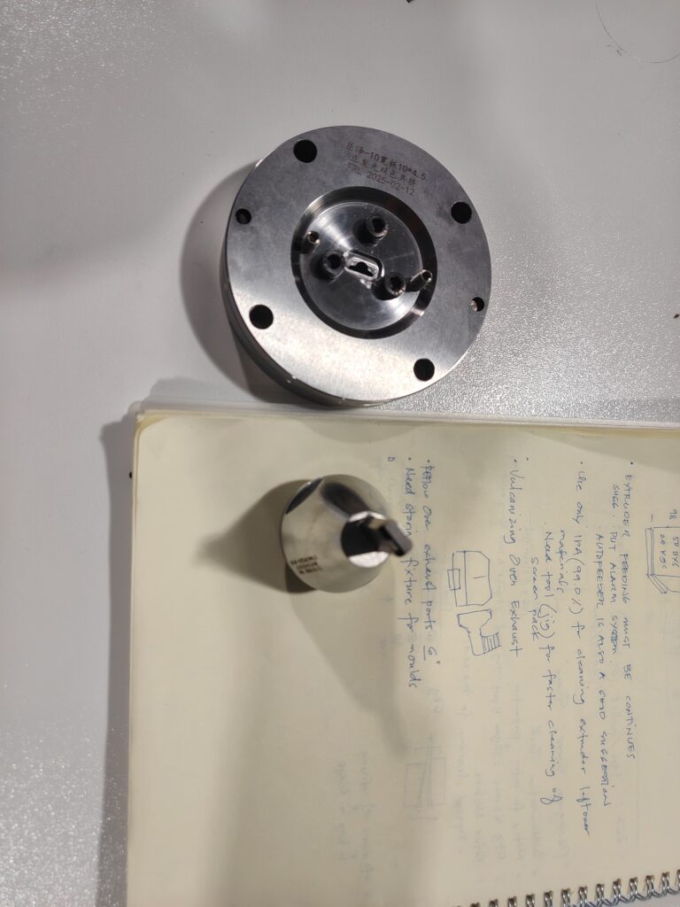 Engineer describing the extrusion mold structure to workers using a whiteboard with handwritten notes.