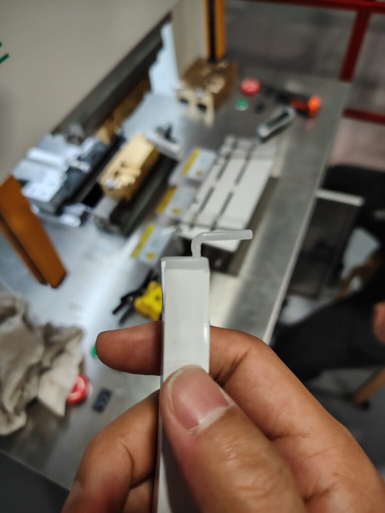 A perfectly molded silicone end cap for an LED strip, still attached to its injection sprue