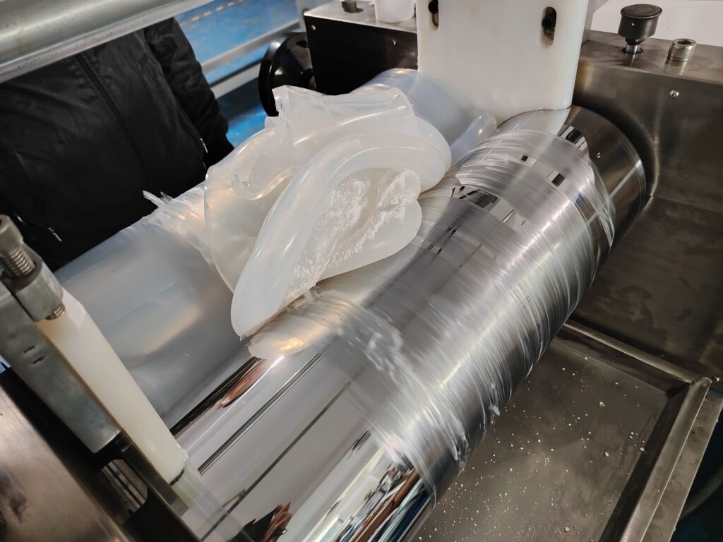 Operator carefully adding platinum-based curing agent to raw silicone polymer in a controlled environment.