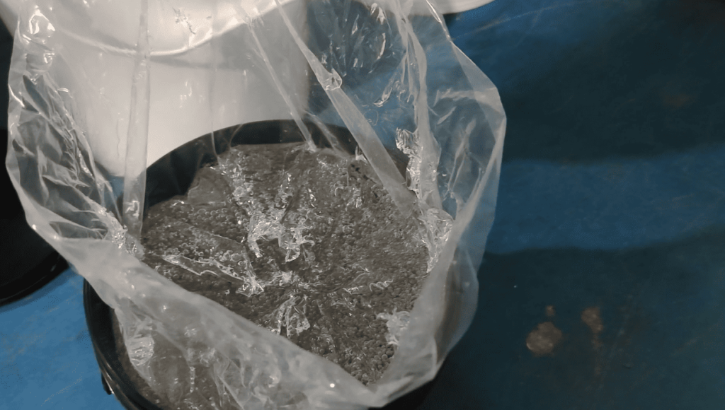 A sealed container (bucket) of platinum-curing catalyst for silicone rubber, stored in the material lab.