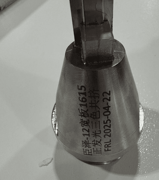 Close-up of an extrusion core mold (mandrel) with a laser-etched date code "2025-04-22".