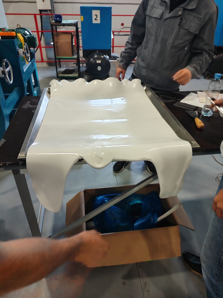 A large sheet of compounded silicone rubber being prepared for cutting into manual feed bars.