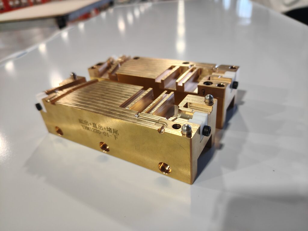 A set of precision end cap injection molds for LED strips, machined from copper alloy.