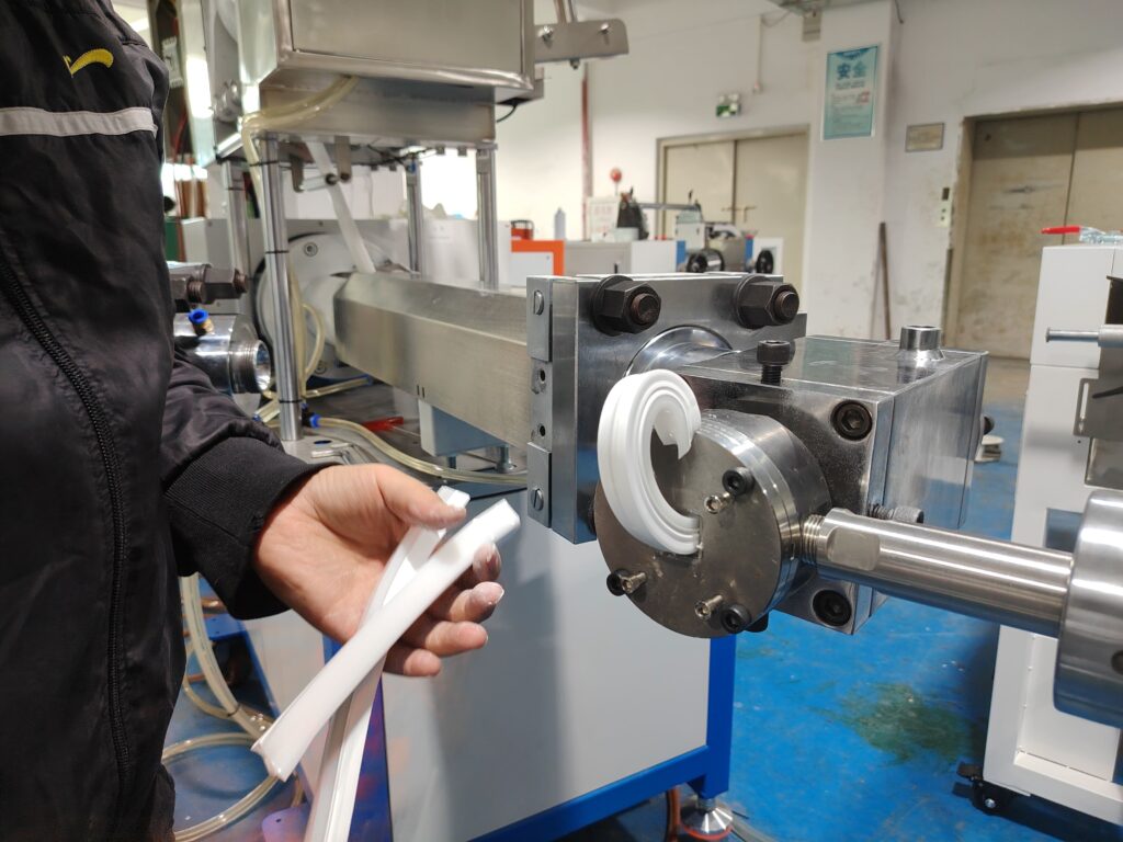 Silicone LED strip bending upward as it exits the mold before process adjustment.