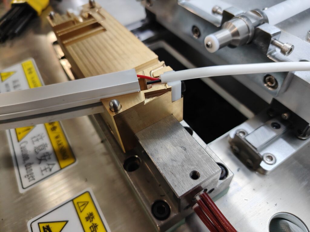 Cut LED strip segments placed in the end cap molding machine, ready for LSR injection.