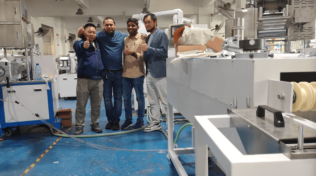 Our engineer and the customer's team posing for a commemorative photo beside the installed extrusion machine after successful training.