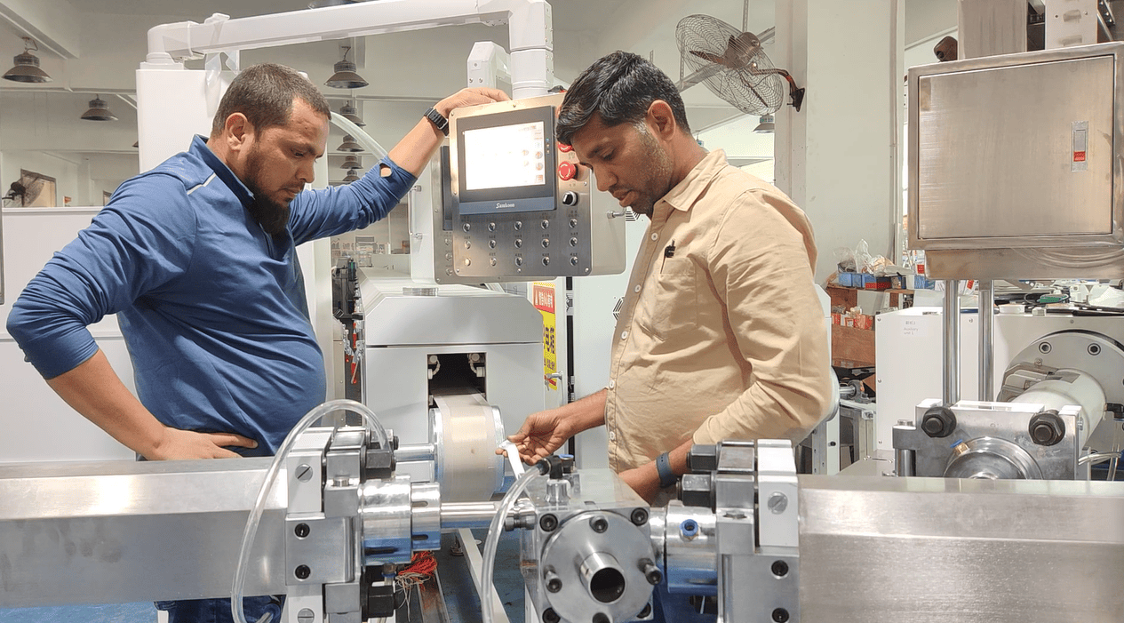 Customer's operator manually guiding the initial silicone rubber LED strip from the mold during line startup in india