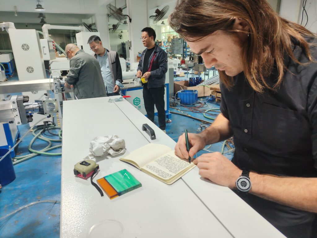 Client's production manager taking detailed notes in his notebook during an extrusion machine training session.