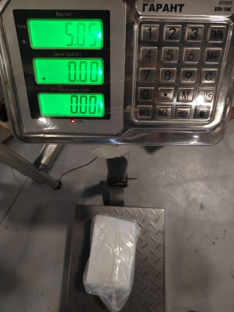 Operator weighing silicone rubber compound or additives on a digital bench scale.